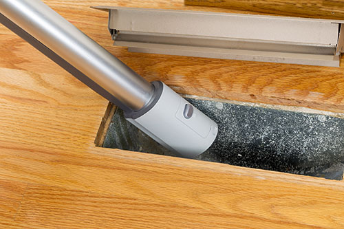 A vacuum cleaning inside a floor vent